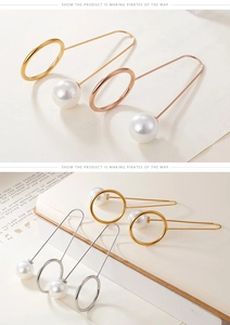 Close-up of minimalist pearl drop earrings in gold, silver, and rose gold finishes