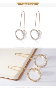 Detail view of long hook earrings featuring pavé cubic zirconia rings and white pearls