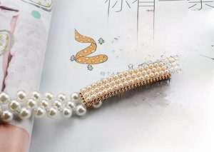 Close-up of elegant stretch pearl waist chain with a gold rectangular pearl buckle