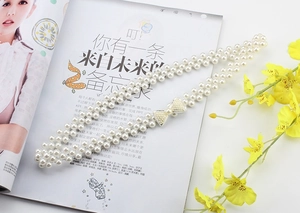 Detail of elegant pearl dress belt with a double-row design and rhinestone bow buckle