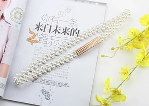 Detail of elegant four-row pearl elastic waist chain with gold rhinestone buckle