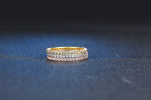Macro detail of three-piece set rings in gold, silver and rose gold with full pavé stones
