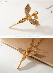 Detail of gold angel wing pendant with sparkling pavé crystals and yellow gemstone