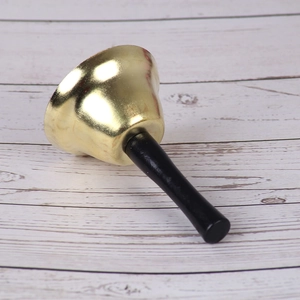 Klassieke 7,5 cm gouden kersthandbel met zwart handvat op witte houten achtergrond
