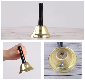Detailopname van gouden handbel met zwart handvat en zilveren klepelstructuur aan de binnenkant