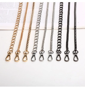 Close-up of various metal chain straps for handbags with lobster clasps in multiple finishes
