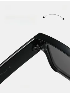 Détail macro des charnières métalliques et des marquages sur les lunettes de soleil noires