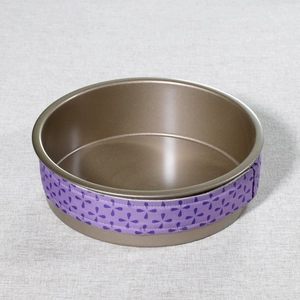 Detail of purple floral bake even strip wrapped around a metal round cake baking pan