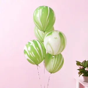Close-up of five green and white marble agate latex balloons with hanging strings