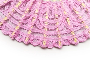 Close-up of pink lace floral embroidery on a vintage bamboo hand fan with detailed texture