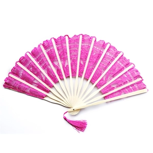 Detail of pink floral lace fabric and light natural wood ribs on a vintage folding fan
