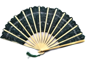 Detail of hand-made dark green lace folding fan with bamboo ribs and matching tassel