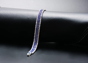Macro view of double-row clear and blue rhinestone bracelet on silver base metal