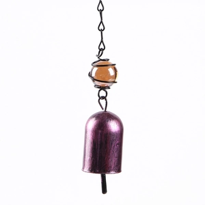 Detailed view of vintage purple metal bell and amber glass bead with black wire wrap