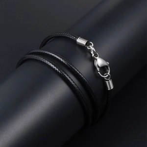Minimalist black braided cord necklace with silver stainless steel clasp on a stand