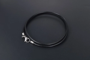 Detail of black braided linen wax cord necklace featuring silver lobster clasp and chain