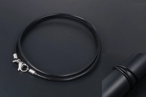 Close-up of black braided flax wax cord with silver lobster clasp and texture detail