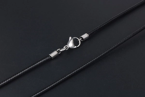 Macro shot of black braided linen wax cord with silver titanium steel lobster clasp
