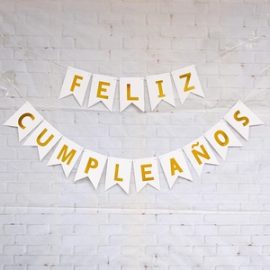 Detail of Feliz Cumpleaños banner with gold letters on white swallowtail cardstock flags