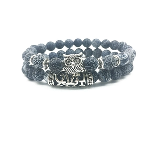 Detail of owl charm and textured dragon vein agate beads on double-layered bracelet