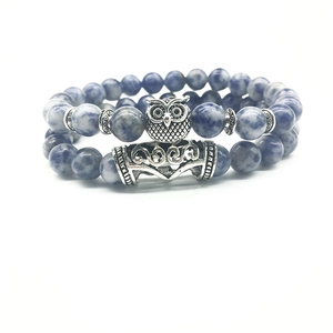 Detail of owl charm and blue marble natural stone beads on a double-layer bracelet