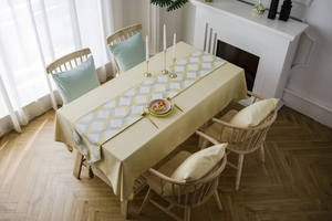 Top-down view of yellow fabric tablecloth with geometric jacquard table runner