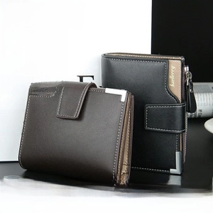 Detail view of men's short leather wallets in black and dark brown with metal corners
