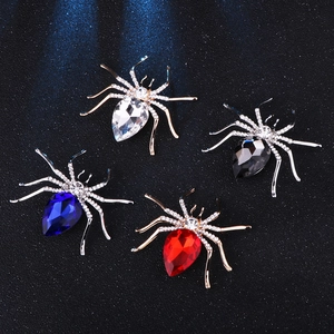 Detailed macro view of sparkling crystal spider brooches in four elegant colors