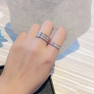 Close-up of double and single row diamond eternity rings in silver on a model hand