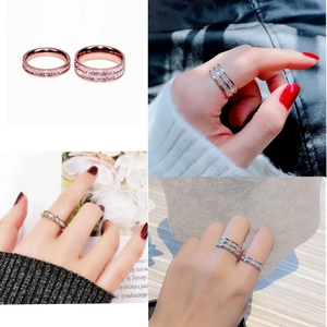 Detail of thin and wide rose gold rings with cubic zirconia inlay on a model