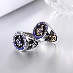 Close-up of Masonic ring with blue enamel, gold G symbol, and intricate side carvings
