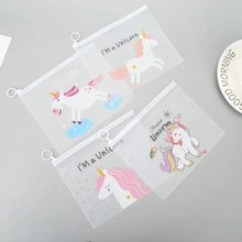 Close-up of four frosted PVC unicorn zipper pouches on a minimalist grey background