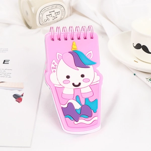 Cute pink unicorn spiral notebook with creative PVC cover on a minimalist desk setup
