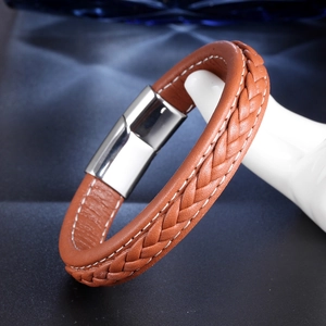Macro shot of brown braided leather bracelet featuring a polished stainless steel magnetic clasp