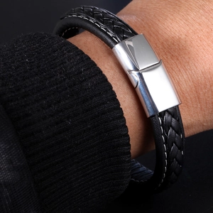 Macro shot of silver magnetic clasp and black braided leather texture on a sleek bracelet