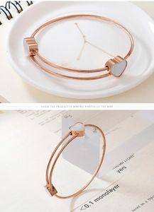 Detailed macro view of rose gold steel wire bracelet with heart-shaped shell inlays