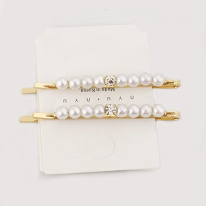 Set of two gold hair clips featuring elegant white pearls and a centered clear rhinestone