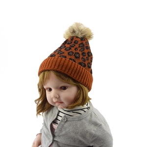 Detail of leopard print knit hat for children featuring a soft faux fur pompom and ribbed cuff