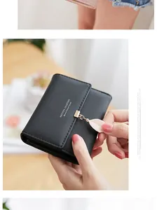 Detailed close-up of a black PU leather wallet featuring a leaf charm and gold hook