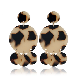Detailed view of tortoiseshell resin C-shaped hoop earrings with gold metal ring link