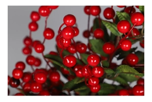 Close-up of vibrant red artificial berries with green leaves for Christmas floral DIY décor