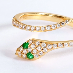 Macro shot of S925 hallmark on gold snake ring with green stone eyes and micro-pave crystals