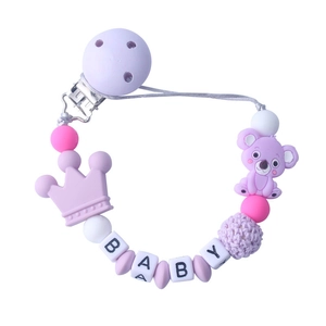 Detail of purple koala silicone pacifier clip with BABY alphabet beads and wooden clamp