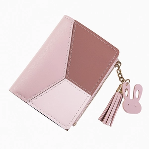 Detail of pink patchwork wallet with zipper, rabbit pendant and tassel decoration