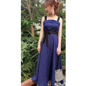 Détail d'une large ceinture en ruban de soie assortie à une robe bleu marine contrastée