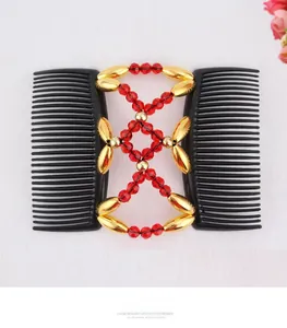 Detail of magic hair comb with red faceted beads and golden metal accents on white background