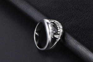 Detailed view of crocodile tooth ring in silver steel finish on black leather texture