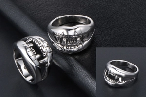 Detailed macro view of silver crocodile teeth ring on textured black leather background