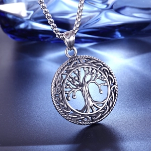 Polished stainless steel Tree of Life pendant necklace with box chain on dark surface