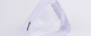 Close-up of a clear PVC triangular cosmetic bag with white trim and silver zipper